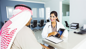 Middle-aged Hispanic patient in a modern medical consultation, attentively listening to a Hispanic doctor explaining the diagnosis of Fabry disease using a digital tablet. This interaction emphasizes effective communication in diagnosing Fabry disease, differentiating it from neurological conditions such as multiple sclerosis, while also addressing issues like neuropathic pain and corneal opacity related to alpha-galactosidase deficiency.